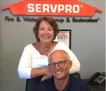 dennis and ellen with SERVPRO sign behind on the wall