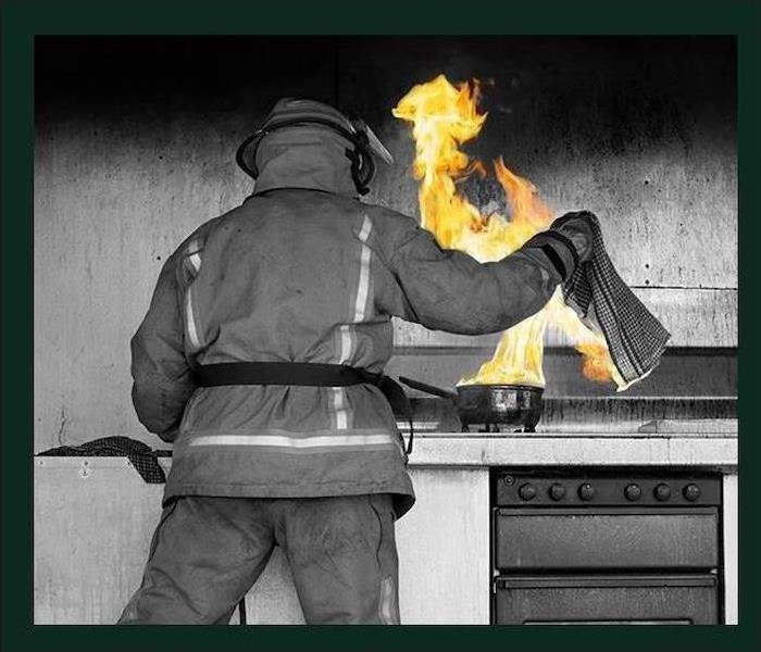 fire fighter putting out kitchen fire 