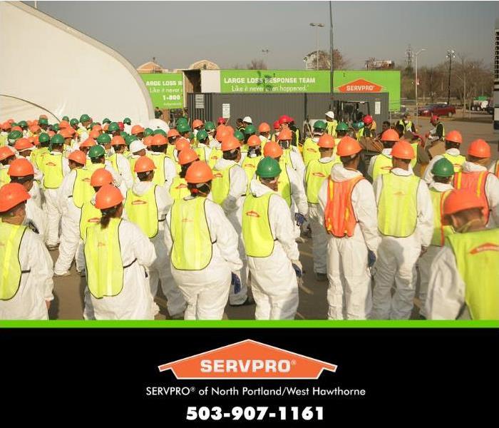 crew of large loss SERVPRO technicians in front of large loss damage 